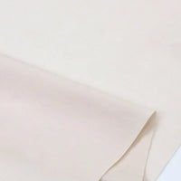 Gros plan sur Popeline polyester-coton au mètre de Longan Craft France, un tissu popeline uni, lisse et respirant, partiellement plié à un coin et présenté sur une surface plane, idéal pour les peignoirs, les chemises et les nappes.