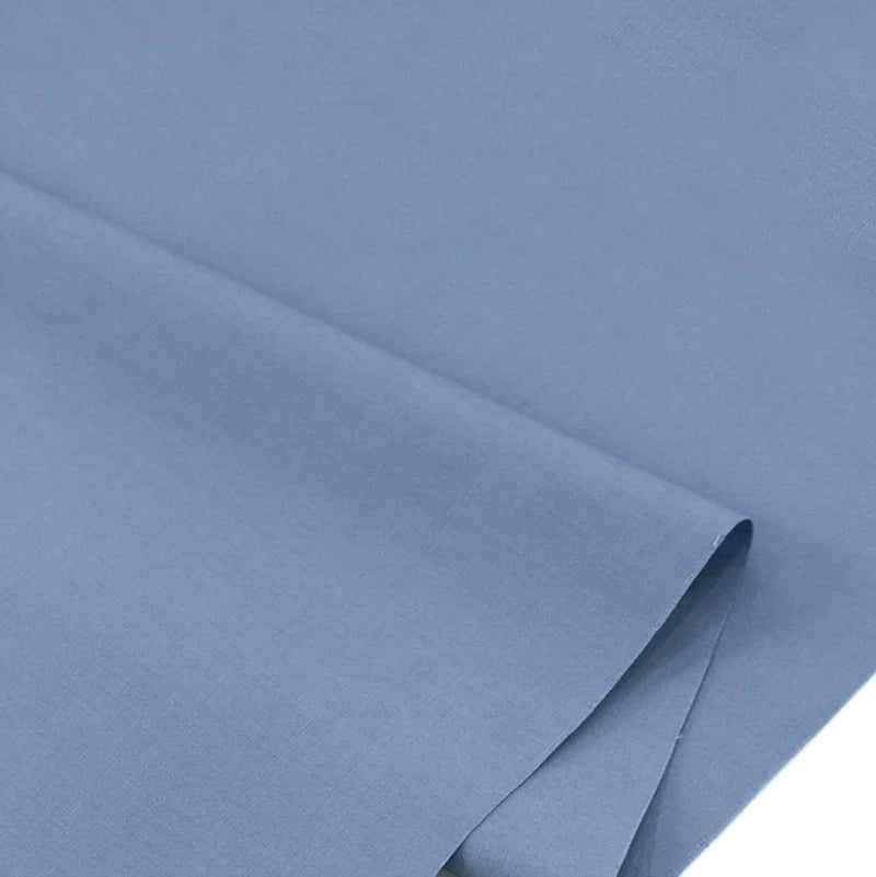 Gros plan sur Popeline polyester-coton au mètre de Longan Craft France, un tissu popeline doux, respirant et uni à armure toile, soigneusement plié avec une texture lisse et sans motifs-idéal pour robes, chemises et nappes.