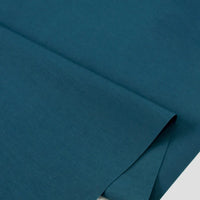 Gros plan sur Popeline polyester-coton au mètre de Longan Craft France, un doux et respirant tissu popeline uni à armure toile, soigneusement plié-idéal pour les peignoirs, chemises ou nappes et divers projets de couture.