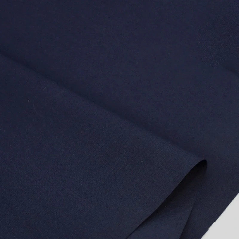 Gros plan sur Popeline polyester-coton au mètre de Longan Craft France, un doux et respirant tissu popeline uni à armure toile, idéal pour les peignoirs, chemises et langes avec sa texture lisse et sa couleur bleu marine profonde.