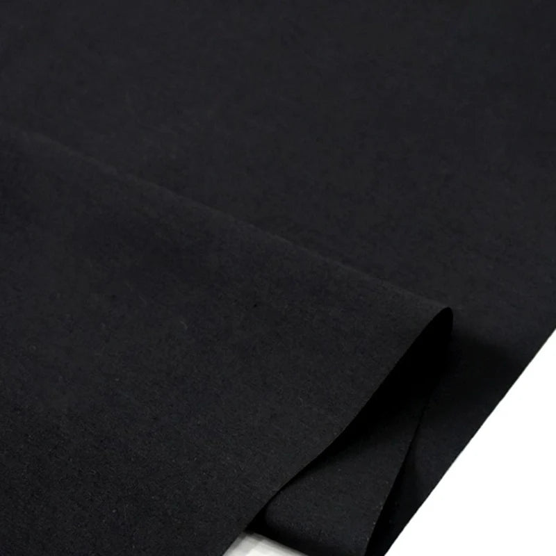 Gros plan sur la popeline polyester-coton au mètre de Longan Craft France, un tissu popeline uni, doux et respirant, idéal pour les robes, les chemises et les nappes. Le tissu est montré partiellement plié sur une surface plane.