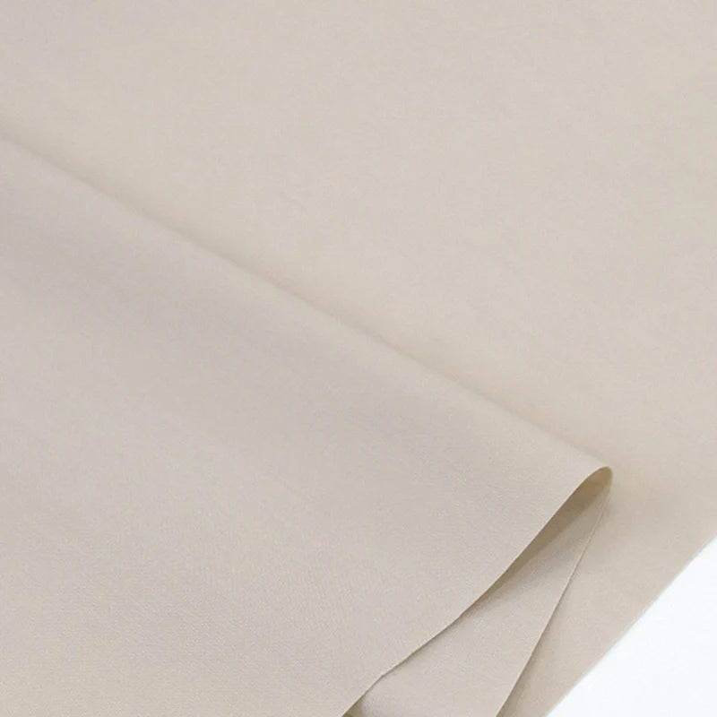 Gros plan sur deux pièces superposées de Popeline polyester-coton au mètre de Longan Craft France, posées à plat pour montrer leur texture lisse et douce et leurs bords soigneusement pliés. Idéal pour robes, chemises et nappes.