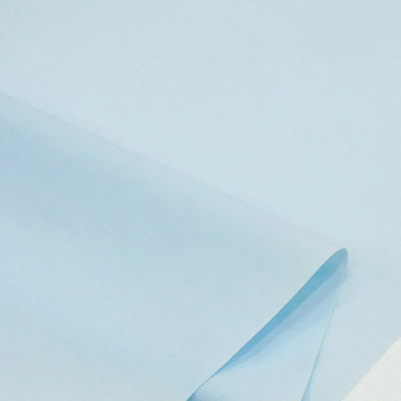Gros plan sur une feuille pliée de Popeline bleu clair en polyester-coton au mètre de Longan Craft France, mettant en valeur la texture raffinée et la durabilité de ce tissu, idéal pour les robes, les chemises et les nappes.