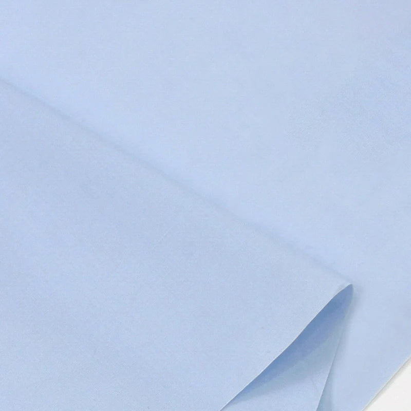 Un gros plan montre Popeline polyester-coton au mètre de Longan Craft France, un doux et respirant tissu popeline uni à armure toile, soigneusement plié avec des plis visibles - idéal pour les peignoirs, chemises et couches.