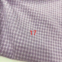 Gros plan sur le tissu seersucker polyester à carreaux vichy au mètre de Longan Craft France, violet et blanc, avec le chiffre 17 en rouge près du centre.