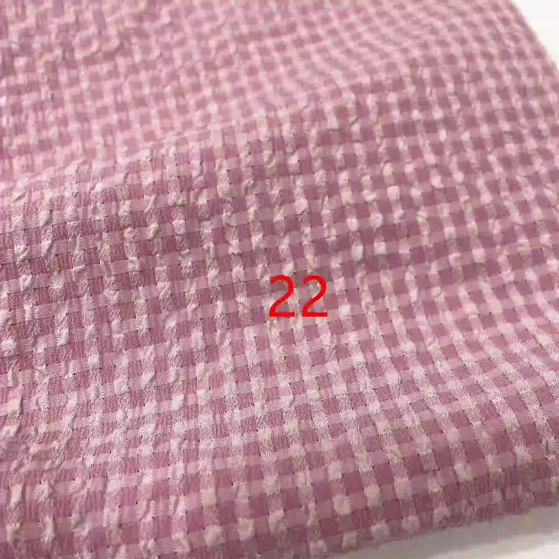 Gros plan sur le tissu Longan Craft France Seersucker polyester à carreaux vichy au mètre, rose et blanc, à l'aspect texturé, avec le chiffre 22 en rouge au centre.