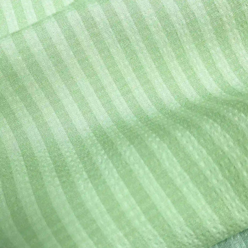 Gros plan sur le Seersucker à larges rayures au mètre de Longan Craft France : polyester seersucker vert clair avec des rayures verticales plus foncées régulièrement espacées et une brillance subtile - idéal pour la décoration intérieure ou les chemises vintage.