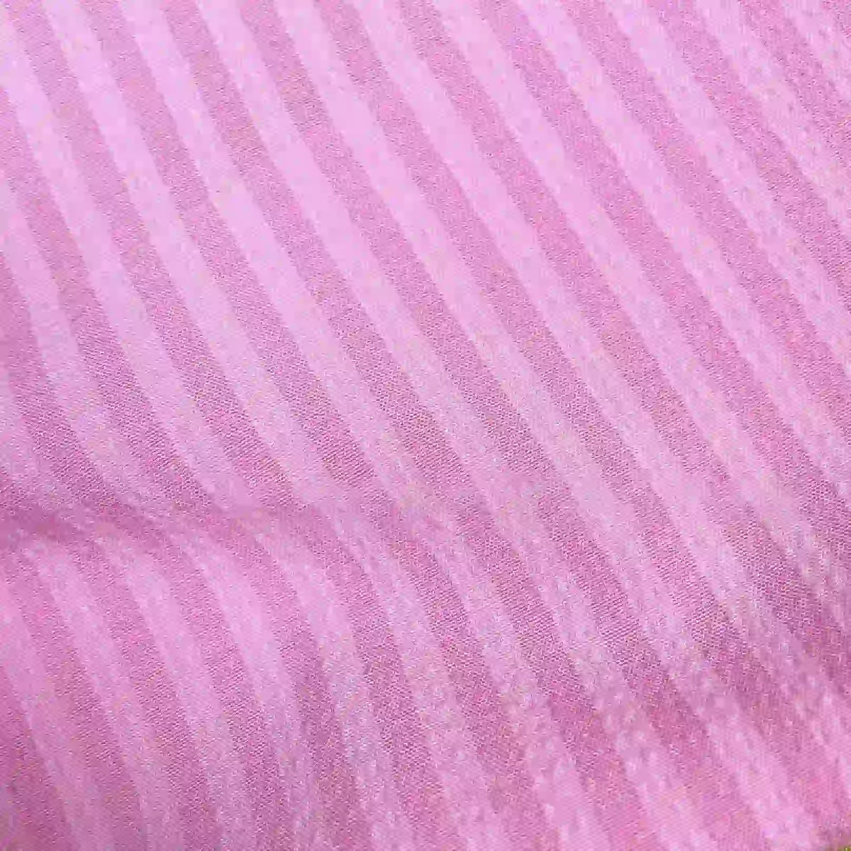 Gros plan sur le Seersucker à larges rayures au mètre de Longan Craft France, un seersucker vintage en polyester aux rayures rose clair et rose foncé alternées. Sa texture légèrement ondulée et respirante est idéale pour la décoration intérieure.
