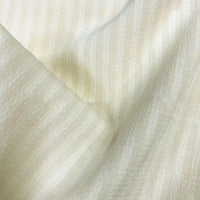 Gros plan sur le Seersucker à larges rayures au mètre de Longan Craft France : un seersucker en polyester crème clair avec de subtiles rayures verticales, une surface légèrement texturée, un drapé doux - idéal pour les chemises vintage ou la décoration intérieure.