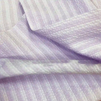 Gros plan sur le Seersucker à larges rayures au mètre de Longan Craft France, un tissu seersucker vintage en polyester violet clair pour chemises, avec des rayures subtiles et une texture douce et brillante - idéal pour la décoration intérieure.