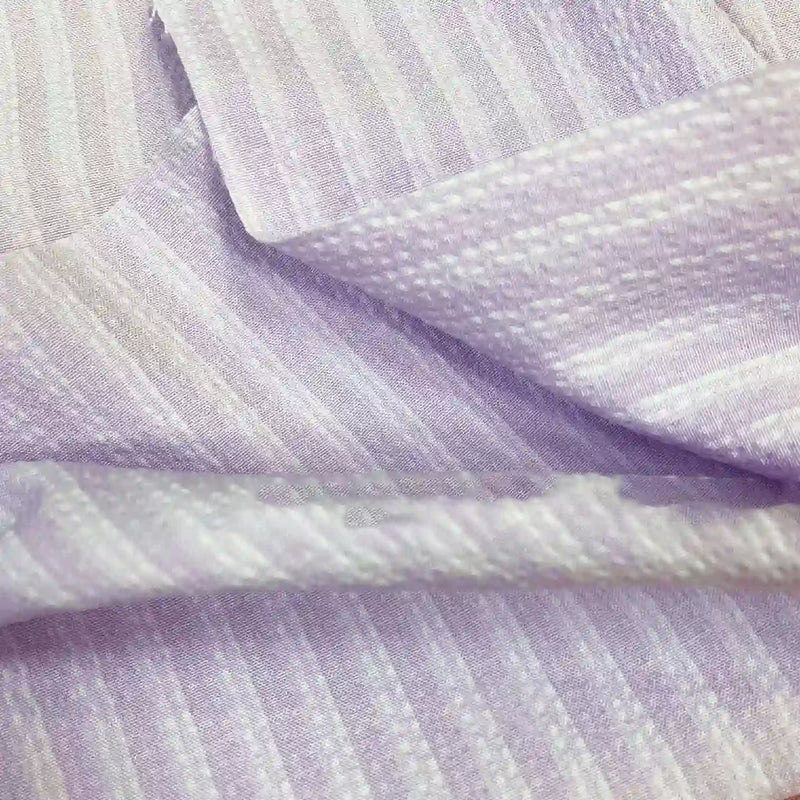 Gros plan sur le Seersucker à larges rayures au mètre de Longan Craft France, un tissu seersucker vintage en polyester violet clair pour chemises, avec des rayures subtiles et une texture douce et brillante - idéal pour la décoration intérieure.