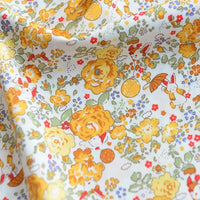 Un gros plan de Longan Craft France Tissu popeline de coton imprimé au mètre, 100% coton uni 40S, à motifs floraux jaunes et oranges avec de petits lapins et champignons, idéal pour DIY, quilting, nappes, robes ou chemises.