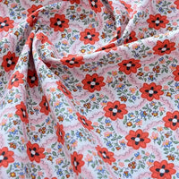 Découvrez de près le tissu popeline de coton imprimé au mètre Longan Craft France : 100 % coton, motifs floraux rouges et multicolores sur fond blanc, doux et souple, idéal pour DIY, quilting, nappes, robes et chemises.
