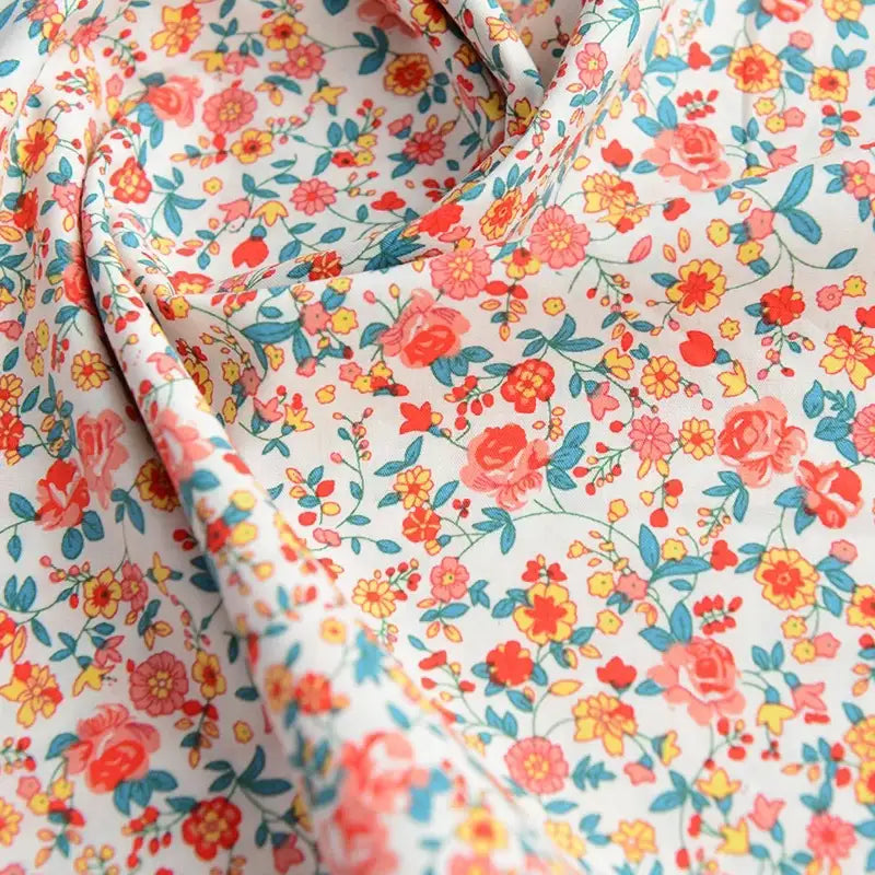 Gros plan sur le Tissu popeline de coton imprimé au mètre par Longan Craft France, 100% coton avec des motifs floraux colorés - idéal pour le bricolage, le quilting, les nappes, les robes et les chemises.