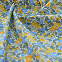 Le tissu popeline de coton imprimé au mètre Longan Craft France présente des motifs floraux jaunes, bleus et orange avec feuillage vert sur fond clair, idéal pour DIY, quilting, nappes, robes ou chemises.