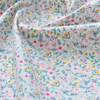 Gros plan sur le Tissu popeline de coton imprimé au mètre par Longan Craft France, unie 40S 100% coton à motifs floraux, idéal pour DIY, quilting, nappes, robes et chemises, drapé doucement et présentant de petites fleurs roses, jaunes et blanches avec des feuilles vertes.
