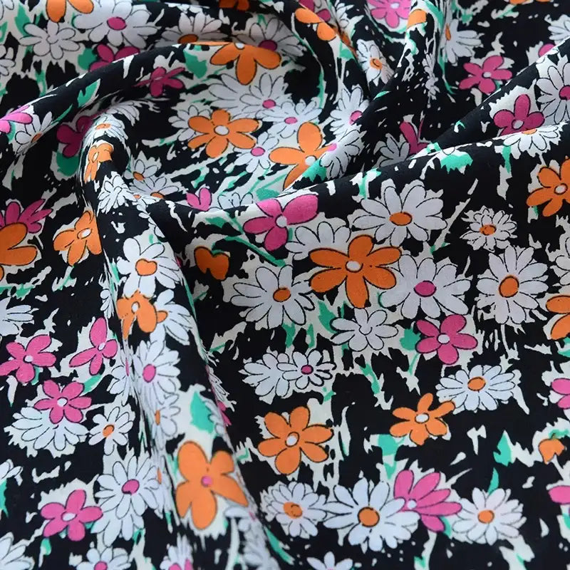 Un gros plan de Tissu popeline de coton imprimé au mètre par Longan Craft France, 100% coton 40S, à motifs floraux colorés sur fond noir, idéal pour DIY, quilting, nappes, robes et chemises.