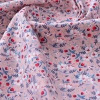 Gros plan sur le tissu popeline de coton imprimé au mètre 100% coton de Longan Craft France, qui présente un motif floral avec des fleurs blanches, rouges et bleues et des feuilles vertes - idéal pour le bricolage, le quilting, les peignoirs, les chemises et les langes.