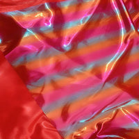 Gros plan sur le Tissu lamé arc-en-ciel au mètre de Longan Craft France, un polyester irisé à rayures dégradées roses, orange, bleues et rouges avec une finition métallique idéale pour costumes de scène ou vêtements spéciaux.