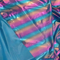 Un tissu lamé arc-en-ciel au mètre de Longan Craft France, en polyester irisé à rayures dégradées bleu, rose et violet, brille à côté d'un tissu bleu mat-parfait pour costumes de scène ou tenues d'événements spéciaux.