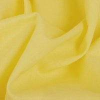 Gros plan sur un voile jaune en rayonne au mètre de Longan Craft France, montrant les plis et la texture. Voile léger uni, parfait pour doublure, couture, vêtements, nappes et rideaux.