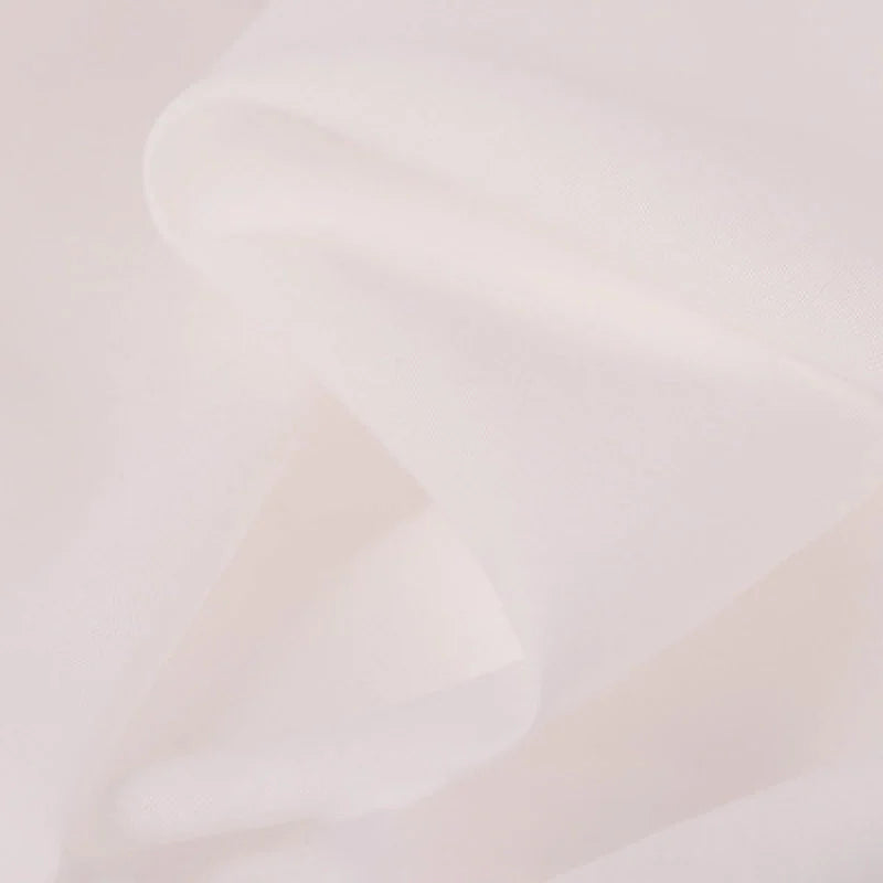 Gros plan sur le tissu voile en rayonne au mètre de Longan Craft France, un voile uni semi-transparent, rose clair ou blanc cassé, idéal pour la couture, les doublures, les vêtements, les nappes et les rideaux. Texture douce et lisse avec des plis légers et une qualité respirante.