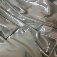 Gros plan sur le satin lamé gris clair brillant de Longan Craft France-Tissu satin lamé au mètre, polyester métallisé et brillant-des plis lisses et un bord non fini, parfaits pour la couture, les robes DIY et la couture créative.