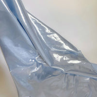 Un morceau de Tissu satin lamé au mètre de Longan Craft France, polyester métallisé et brillant, est drapé sur une surface blanche. Sa finition brillante et son aspect réfléchissant le rendent parfait pour la couture, les peignoirs DIY et les travaux manuels.