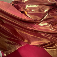 Gros plan sur le Tissu satin lamé au mètre de Longan Craft France, un tissu métallisé en polyester brillant avec des irisations rouges et dorées, idéal pour la couture, les robes DIY et l'artisanat.