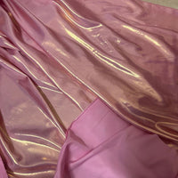 Un gros plan du Tissu satin lamé au mètre de Longan Craft France montre sa surface brillante en polyester métallisé superposée à un rose mat, reflétant la lumière-idéal pour couture, robes DIY ou travaux manuels.