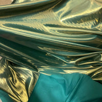 Gros plan sur le Tissu satin lamé au mètre de Longan Craft France, un tissu polyester métallisé brillant drapé sur un tissu sarcelle mat, parfait pour la couture, les robes DIY et l'artisanat.