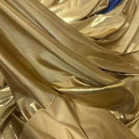 Le Tissu satin lamé au mètre de Longan Craft France présente une finition métallique avec des plis et des reflets élégants, ainsi qu'une touche de bleu en arrière-plan - idéal pour les robes de chambre DIY, la couture ou les travaux manuels.
