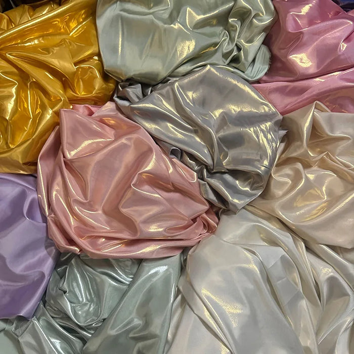 Les tissus satin lamé brillants et froissés de Longan Craft France dans les tons pastel jaune, argent, rose, lavande et crème sont superposés de façon désordonnée. Tissu satin lamé au mètre : polyester métallisé et brillant - idéal pour la couture et les projets de bricolage.