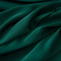 Le Tissu mousseline satinée au mètre de Longan Craft France est un tissu vert foncé, extensible et soyeux, à la texture fluide, parfait pour les vêtements élégants.