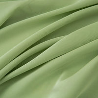 Le Tissu mousseline satinée au mètre de Longan Craft France présente une texture vert clair, douce et lisse avec une finition mate, idéale pour les robes de soirée élégantes ou les projets créatifs.