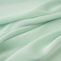 Découvrez le Tissu mousseline satinée au mètre de Longan Craft France - vert clair, extensible, soyeux et subtilement brillant. Parfait pour les robes de soirée élégantes ou les créations personnalisées avec son drapé doux et ses plis délicats.
