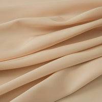Gros plan sur le tissu mousseline satinée au mètre de Longan Craft France, extensible et soyeux, de couleur beige clair avec des plis doux - idéal pour les robes de soirée ou à acheter comme tissu au mètre pour des créations élégantes.