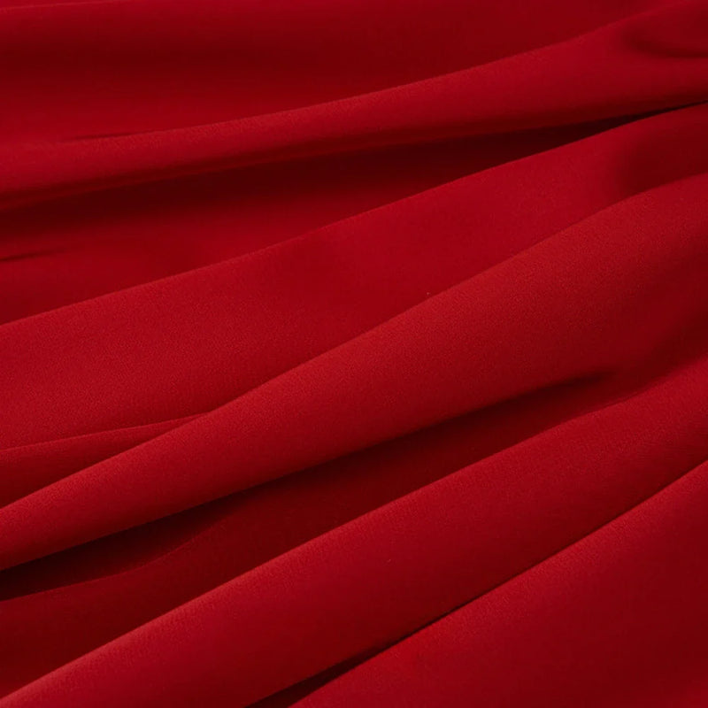 Gros plan sur le Tissu mousseline satinée au mètre de Longan Craft France, un tissu extensible, doux et soyeux d'un rouge éclatant, parfait pour les tenues de soirée élégantes et les créations vestimentaires.