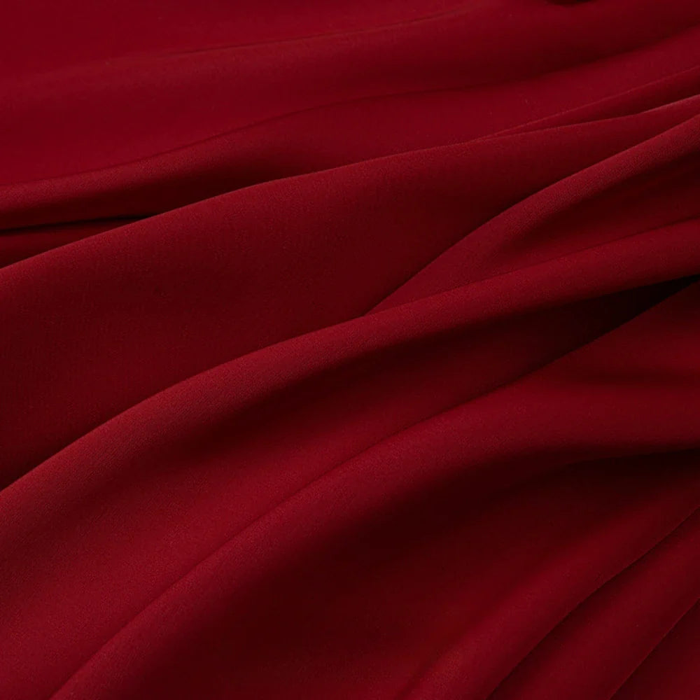 Gros plan sur le Tissu mousseline satinée au mètre de Longan Craft France, un tissu rouge foncé, extensible et doux comme de la soie, aux plis souples, idéal pour les robes de soirée élégantes ou pour commander un tissu au mètre.