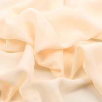 Gros plan sur la "Mousseline légère transparente au mètre" de Longan Craft France, une mousseline de polyester beige clair, fine et douce, à la texture légèrement diaphane, drapée librement en plis doux.