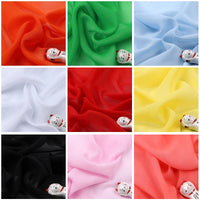 Une grille de neuf carrés présente la Mousseline légère transparente au mètre de Longan Craft France dans les couleurs orange, vert, bleu clair, blanc, rouge, jaune, noir, rose et crème. Chaque carré accueille une figurine de chat en céramique sur le tissu en polyester transparent.