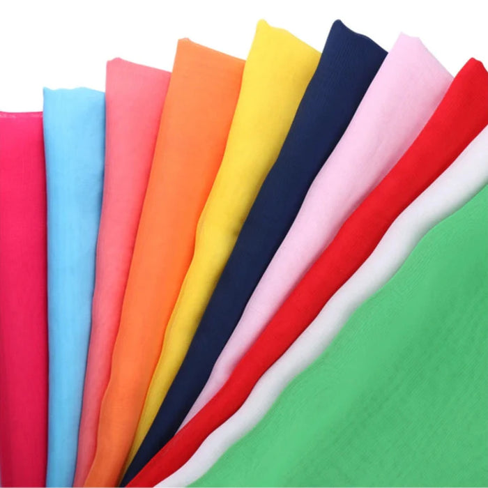 Un éventail de dix échantillons de tissu transparent Mousseline léger de Longan Craft France, comprenant du rose, du bleu, de l'orange, du jaune, du marine, du rose pâle, du rouge, du blanc et du vert en mousseline de polyester. Présentés sur un fond blanc.