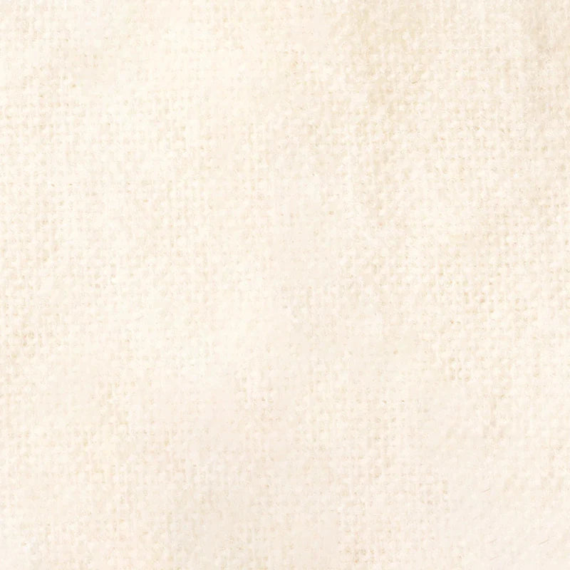 Un gros plan de la Flanelle de coton uni au mètre de Longon Craft France montre sa texture douillette, blanc cassé, avec un subtil motif pointillé. Elle est parfaite comme flanelle d'automne pour les câlins.