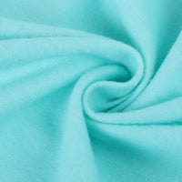 Gros plan sur la Flanelle de coton uni au mètre de Longon Craft France, une douce flanellette bleu clair confortable d'automne, disposée en tourbillon-idéal tissu super douillet pour câlins et parfait pour pyjamas.