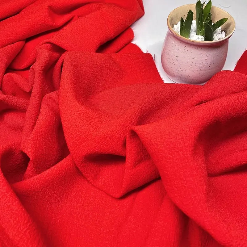 Un petit pot rose avec une succulente verte repose à côté du tissu seersucker de Longan Craft France - Tissu seersucker uni texturé au mètre, froissé polyester, à carreaux - dont les plis texturés évoquent la légèreté d'une tenue d'été.