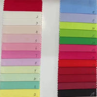 Deux colonnes de Longan Craft France Popeline de coton extensible 40S en rouge, rose, bleu, vert, jaune, aqua et noir - numérotées de 1 à 12 (à gauche) et de 18 à 28 (à droite) - sont présentées sur un fond blanc pour les chemises, les robes et les travaux manuels.