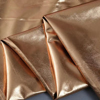 Un gros plan du tissu lamé stretch au mètre de Longan Craft France montre sa surface brillante et réfléchissante et sa texture lisse - un tissu polyester idéal pour la couture, les projets créatifs et l'ameublement.