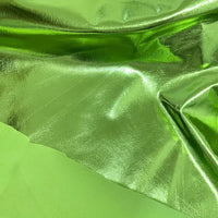 Un gros plan montre deux tissus verts de Longan Craft France : l'un est un tissu lamé brillant en polyester extensible avec une finition réfléchissante, l'autre est mat et lisse - tous deux présentés à plat avec des plis visibles. Idéal pour la couture, les projets créatifs et l'ameublement.