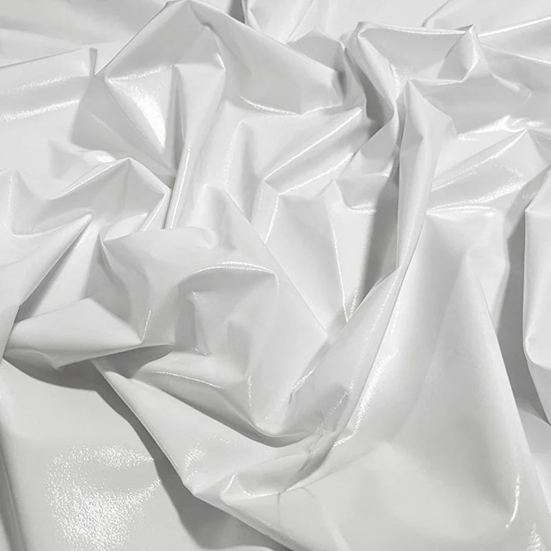 Un gros plan du Tissu lamé blanc brillant stretch au mètre de Longan Craft France montre des plis proéminents qui reflètent la lumière - idéal pour la couture, les loisirs créatifs et la tapisserie d'ameublement.