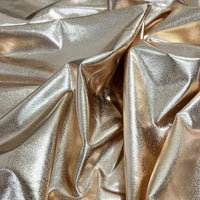 Gros plan sur le tissu lamé stretch au mètre de Longan Craft France, un polyester brillant dont les plis reflètent la lumière pour un effet brillant - parfait pour la couture, les loisirs créatifs, la tapisserie et les costumes de scène précieux.